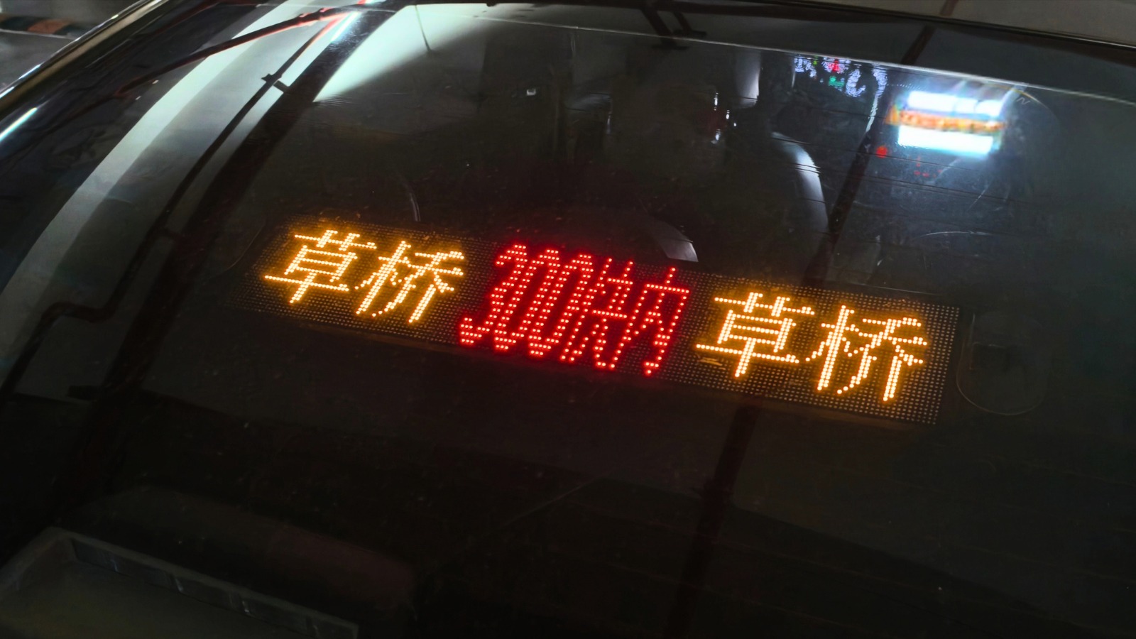 真·LED屏贴在私家车后挡风玻璃内侧，橙色「草桥」到站信息显示